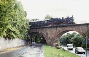 Teilausschnitt des Viaduktes Nonnweiler. Über das Viadukt fährt die Museumsbahn, unter dem Viadukt führt eine Straße auf der 2 Autos fahren. 