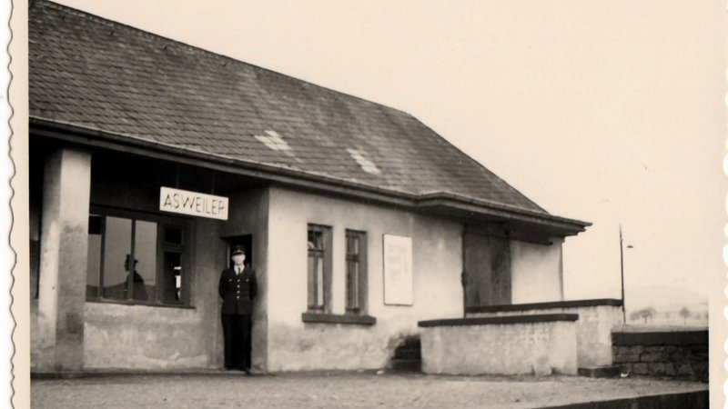 alte schwarz-weiß Fotografie von 1959, die das frühere Bahnhofsgebäude von Asweiler zeigt